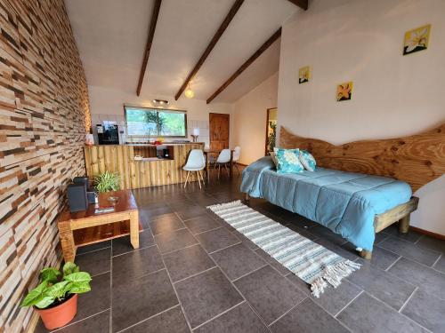 Un dormitorio con una cama y una sala de estar. en Cabañas Kainga, en Hanga Roa