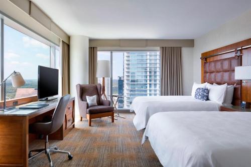 a hotel room with two beds and a desk with a computer at JW Marriott Austin in Austin