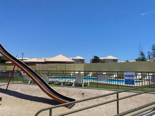 um escorrega num parque infantil com piscina em Departamentos Caldera Suites em Caldera