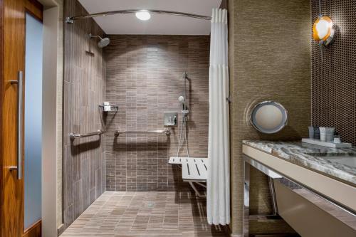 baño con ducha a ras de suelo junto a un lavabo en JW Marriott Austin, en Austin