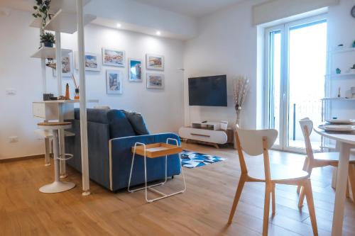 a living room with a blue couch and a table at JLH Aparts - Just Like Home in Bari