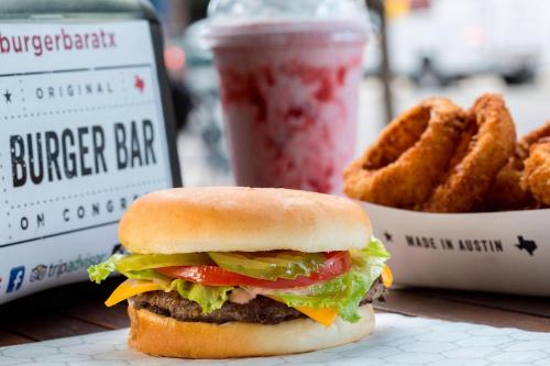 a hamburger and a drink and a basket of onion rings at JW Marriott Austin in Austin