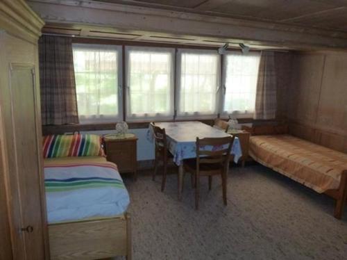 1 dormitorio con 2 camas, mesa y 1 cama en Neuegg, en Lütisburg