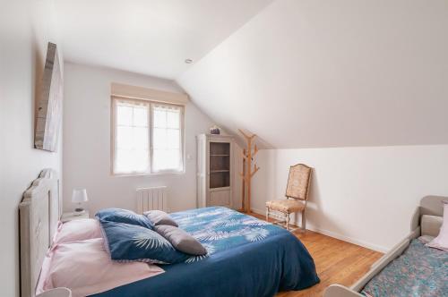 um quarto com uma cama com lençóis azuis e uma janela em La Grange Peyrat em Montagnac-la-Crempse