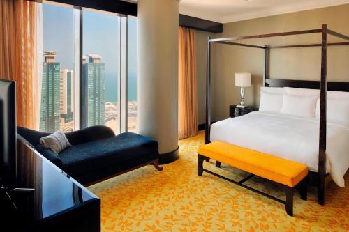 a bedroom with a bed and a chair and a window at Marriott Marquis City Center Doha Hotel in Doha