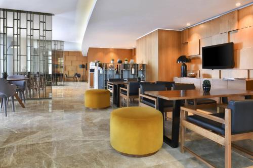a restaurant with tables and chairs and a tv at Marriott Marquis City Center Doha Hotel in Doha
