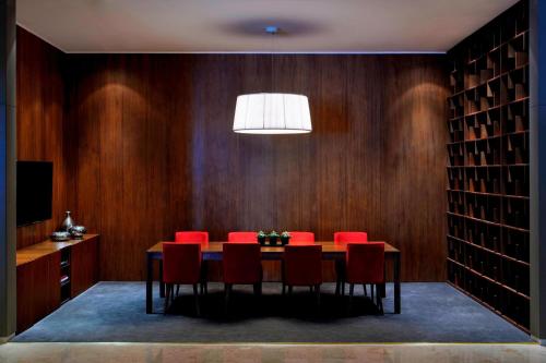 a dining room with a table and red chairs at Marriott Marquis City Center Doha Hotel in Doha