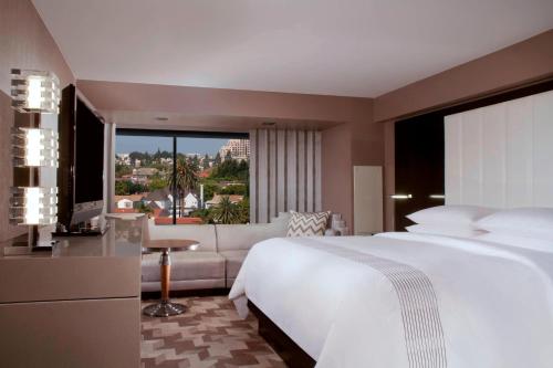 ロサンゼルスにあるビバリー ヒルズ マリオットのベッドルーム(大きな白いベッド1台、ソファ付)