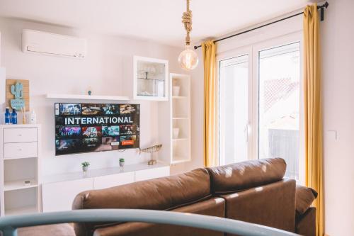 uma sala de estar com um sofá e uma televisão em Duplex Victoria Beach Málaga em Cala del Moral
