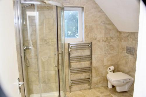 y baño con ducha y aseo. en Contractor's Haven- 4-Bedroom House with Free Parking, Super Fast WiFi, Fran Properties in Aylesbury, Pets are Welcome en Buckinghamshire