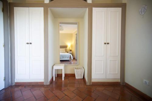 a room with white doors and a bedroom with a bed at Cegonha Country Club in Vilamoura