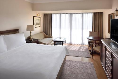 a hotel room with a large bed and a desk at Marriott Mena House, Cairo in Cairo