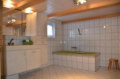 a white tiled kitchen with a sink and a counter at Breiten in Brunnadern