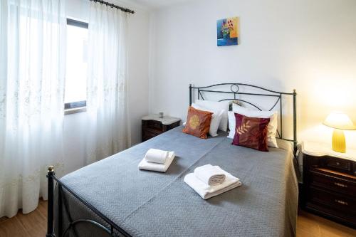 ein Schlafzimmer mit einem Bett mit zwei Handtüchern darauf in der Unterkunft Rustic Old Town - T3 in Albufeira