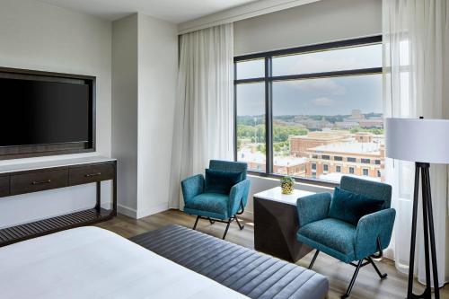 Habitación de hotel con 1 cama, 2 sillas y TV en UNC Charlotte Marriott Hotel & Conference Center, en Charlotte
