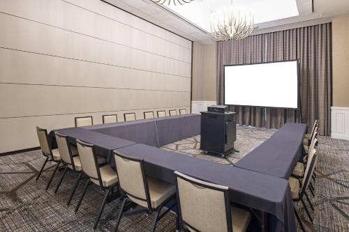 a conference room with a table and chairs and a screen at SpringHill Suites by Marriott Fort Worth Historic Stockyards in Fort Worth