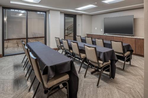 a conference room with a table and chairs and a screen at SpringHill Suites by Marriott Fort Worth Historic Stockyards in Fort Worth