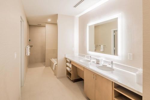 Baño blanco con lavabo y espejo en SpringHill Suites by Marriott Fort Worth Historic Stockyards en Fort Worth