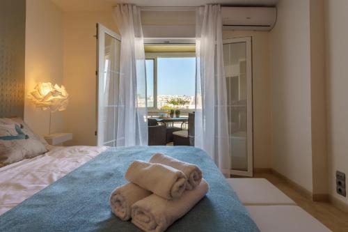 a bedroom with towels on a bed with a view at MalagaSuite Carihuela Seaviews in Torremolinos