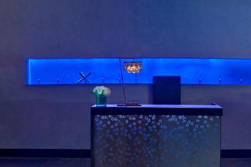 a blue room with a table with a vase of flowers at W Austin in Austin