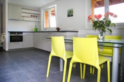 沙爾多納的住宿－Ferienwohnung im Bauernhaus，厨房配有黄色的椅子和桌子