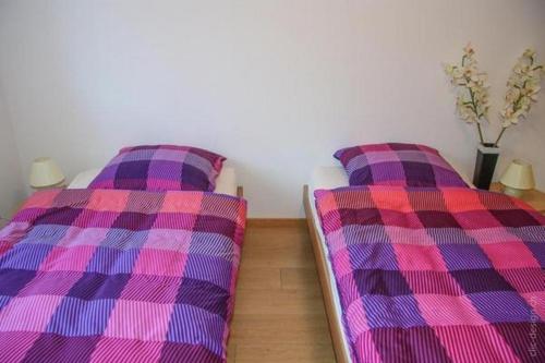 dos camas sentadas una al lado de la otra en una habitación en Ferienwohnung im Bauernhaus, en Chardonne