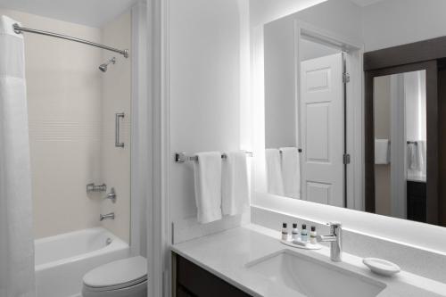 a bathroom with a sink and a toilet and a mirror at Residence Inn Fort Worth Cultural District in Fort Worth