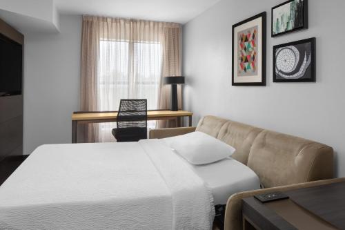 Habitación de hotel con cama y sofá en Residence Inn Fort Worth Cultural District, en Fort Worth
