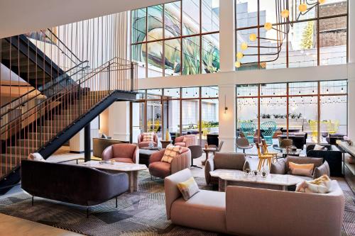 a lobby with couches and chairs and a staircase at The Clancy, Autograph Collection in San Francisco