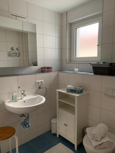 a bathroom with a sink and a toilet and a mirror at Wohlfühl-Apartment in Ettlingen