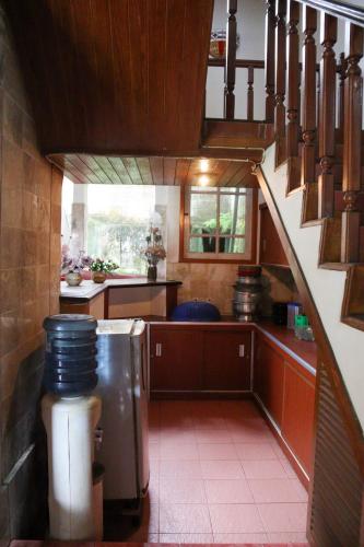 a kitchen with a spiral staircase in a house at Villa saung panenjoan in Puncak