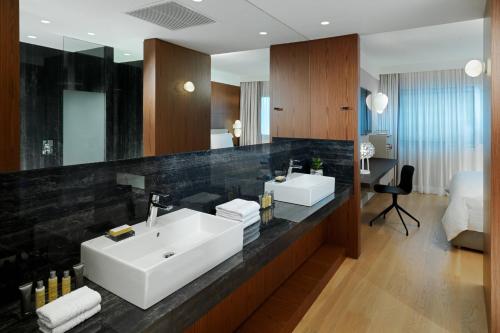 a bathroom with two sinks and a large mirror at Athens Marriott Hotel in Athens