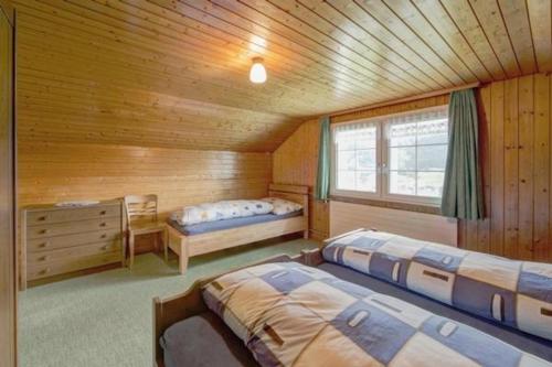 a bedroom with two beds in a wooden cabin at Ferienwohnung Hautle in Gais
