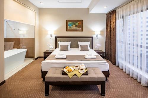 Habitación de hotel con cama y bañera en Taurus Hotel & SPA en Leópolis