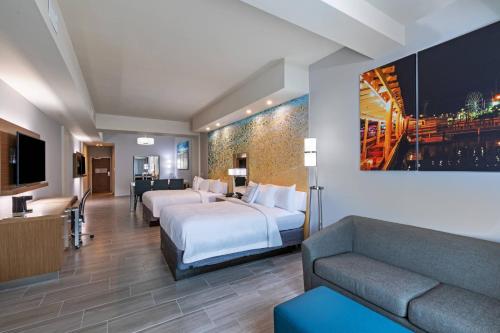 サウス・パドレ・アイランドにあるCourtyard South Padre Islandのベッド2台とソファが備わるホテルルームです。