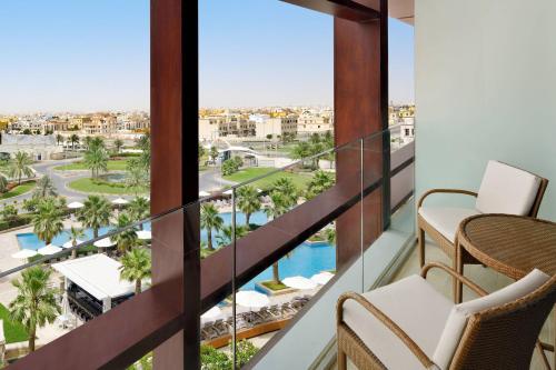 balkon z widokiem na basen i palmy w obiekcie Marriott Hotel Al Forsan, Abu Dhabi w Abu Zabi