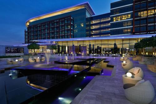 a building with tables and chairs in front of it at Marriott Hotel Al Forsan, Abu Dhabi in Abu Dhabi