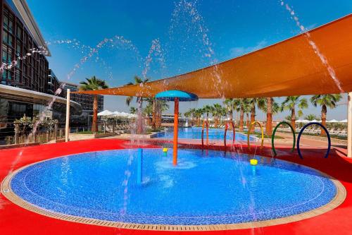 a large swimming pool with a water fountain at Marriott Hotel Al Forsan, Abu Dhabi in Abu Dhabi