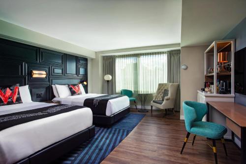 a hotel room with two beds and a desk at W Boston in Boston