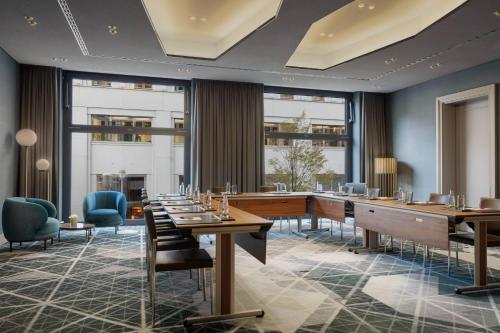 a restaurant with tables and chairs and large windows at Berlin Marriott Hotel in Berlin