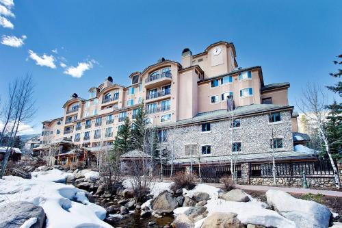 a large building with a river in front of it at Beaver Creek Lodge, Autograph Collection in Beaver Creek