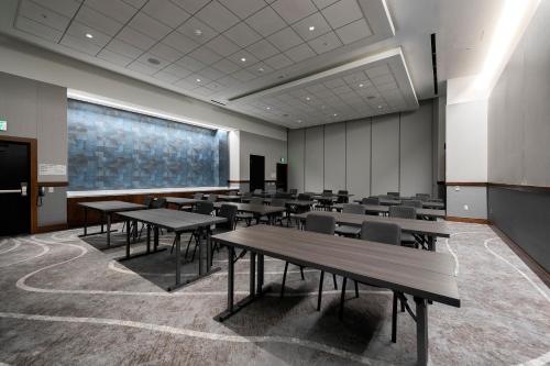 a classroom with tables and chairs and a large screen at Le Meridien Pasadena Arcadia in Arcadia