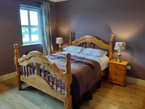 Un dormitorio con una gran cama de madera y una ventana en Whitethorn Lodge, Bed & Breakfast, Lackafinna, en Cong