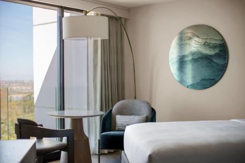 a hotel room with a bed and a chair and a window at VEA Newport Beach, a Marriott Resort & Spa in Newport Beach
