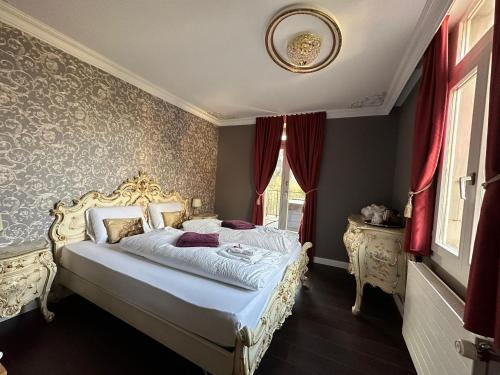 a bedroom with a large bed with red curtains at Historisches Hotel Bären in Kiental