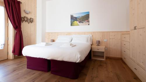 a bedroom with a large bed with white sheets at Italianway - Ripa Fontana 1 Mono in Valdidentro