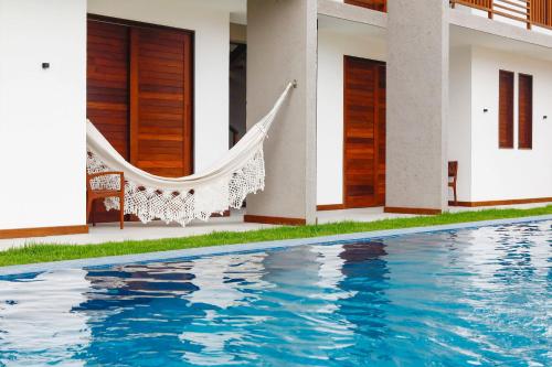 佩德拉斯港的住宿－Pousada Praia do Patacho，一个带吊床和游泳池的房子