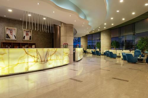 a lobby of a building with chairs and tables at Four Points By Sheraton Kuwait in Kuwait