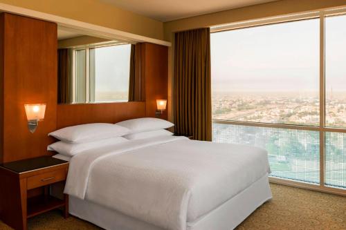 a bedroom with a large bed and a large window at Four Points By Sheraton Kuwait in Kuwait
