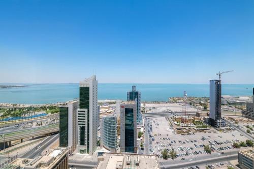 a city skyline with tall buildings and the ocean at Four Points By Sheraton Kuwait in Kuwait